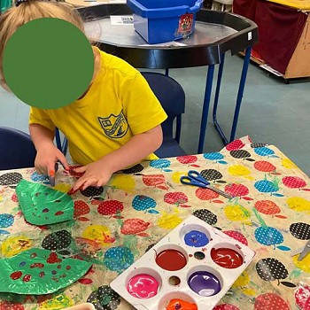 A child finger painting in the classroom