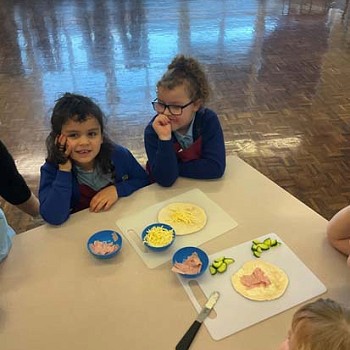 Children enjoying making homemade pizzas in the cookery club